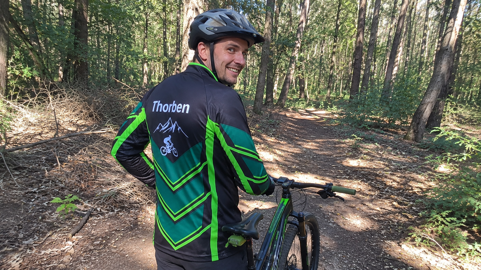 MTB Trikot mit Name und individuellem Rückendesign Mountainbiker im schwarz-grünen Jersey mit Name auf dem Rücken